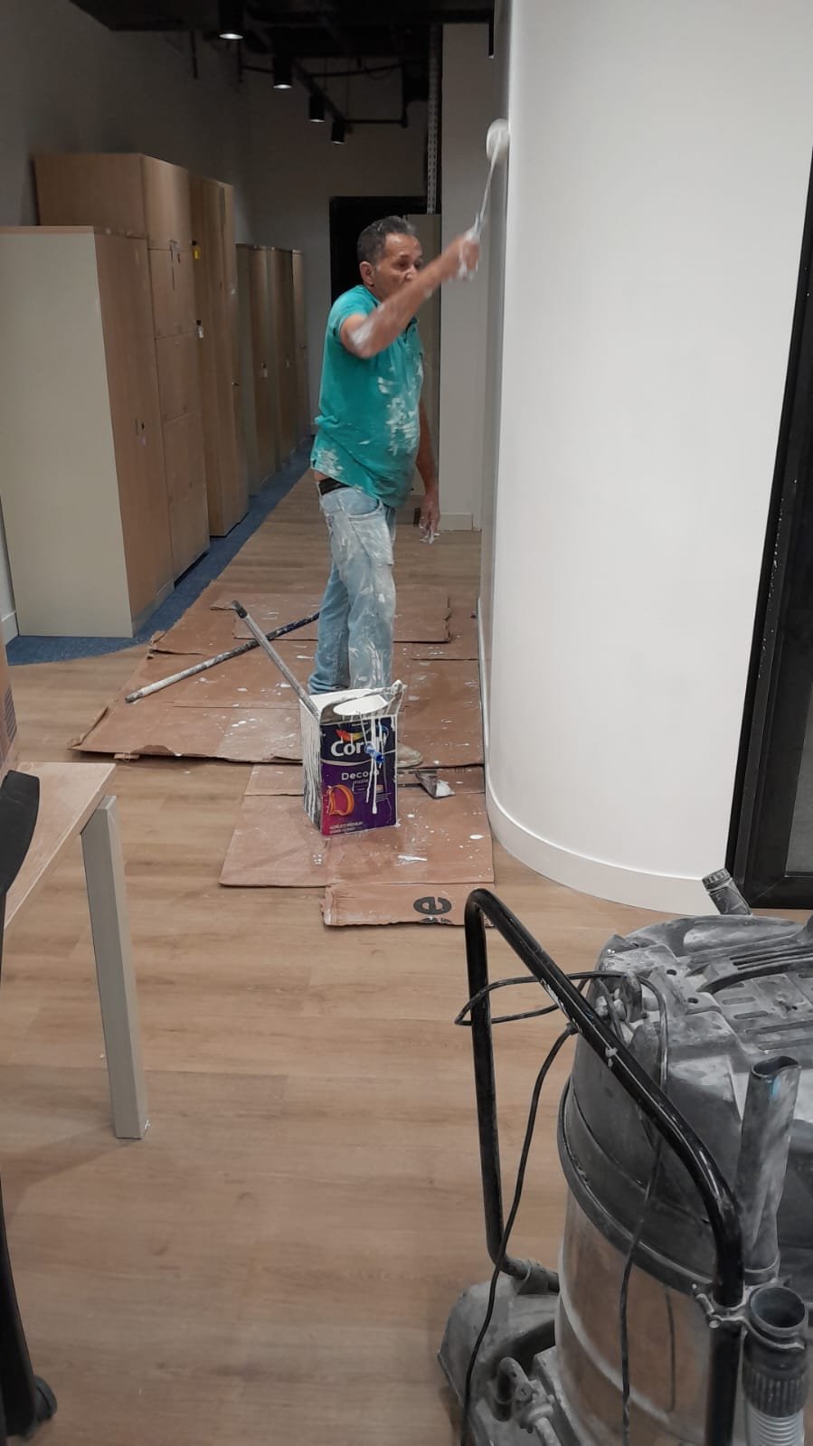 Profissional pintando coluna em corredor de escritório
